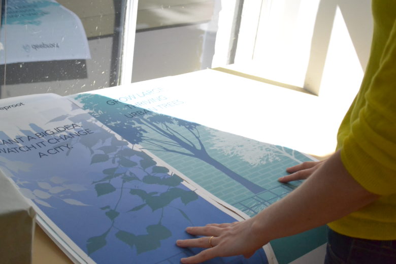 Plant a Big Idea. Watch it Change a City” - Leda studies proofs for DeepRoot’s new tradeshow banner stands.